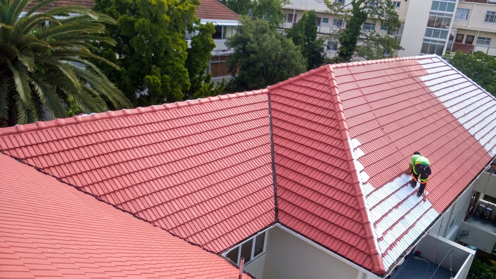 CBM worker applying roof coating on the tiled roof at Exmoor Court in Rondebosch